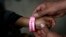 A child wears a bracelet marked with a number that indicates his place in line to submit his request for U.S. asylum, inside a shelter at Bachilleres gymnasium in Ciudad Juarez, Mexico, Feb. 19, 2019.