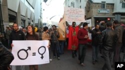 Seorang aktivis perempuan memegang poster yang menunjukkan kesetaraan gender dalam sebuah aksi di Rabat, Maroko, pada 4 Desember 2011. (Foto: AP/Paul Schemm)