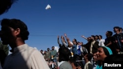 Flood victims try to catch relief material being given to them by Indian police personnel in Srinagar, Sept. 13, 2014. 