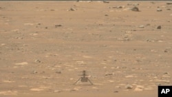 This April 29, 2021 image from video made available by NASA shows the Mars Ingenuity helicopter remained on the ground that was supposed to lift off on its longest, fastest flight yet.