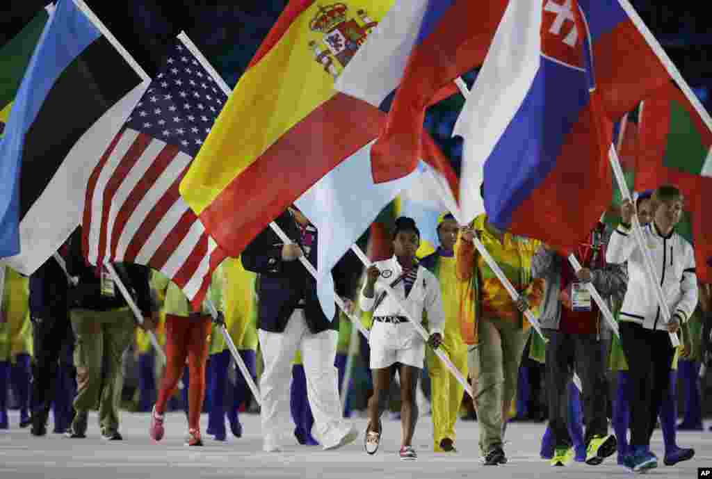 Bintang olahraga senam AS Simone Biles membawa bendera Amerika dalam upacara penutupan Olimpiade Musim Panas 2016 di Rio de Janeiro, Brazil (21/8). (AP/Matt Dunham)