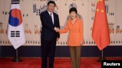 中国国家主席习近平（左）与韩国总统朴槿惠在首尔青瓦台举行峰会前握手（2014年7月3日）