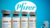 FILE PHOTO: Vials and medical syringe are seen in front of Pfizer logo in this illustration