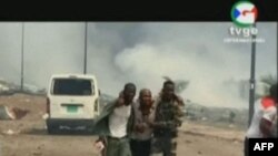 Rekaman video yang diperoleh AFPTV dari TVGE pada 7 Maret 2021 ini memperlihatkan seorang pria terluka sedang dibantu oleh tentara di Bata, Guinea Khatulistiwa.(AFP Photo/TVGE) 