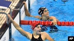 Britain's Siobhan-Marie O'Connor, left, and United States' Maya DiRado smile as they check their times after a women's 200-meter individual medley heat during the swimming competitions at the 2016 Summer Olympics, Monday, Aug. 8, 2016.