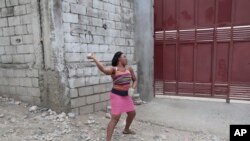 Una mujer lanza piedras a la puerta de una iglesia el 27 de agosto de 2023, luego de que varias personas murieron durante una marcha religiosa para expulsar a una pandilla de Canaan, en Puerto Príncipe, Haití. 