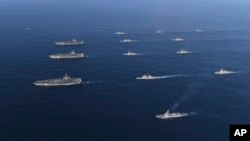 Dalam foto 12 November 2017 yang dirilis oleh Departemen Pertahanan Korea Selatan, tiga kapal induk pembawa pesawat tempur, yaitu USS Nimitz, kiri atas, USS Ronald Reagan, kiri tengah, dan USS Theodore Roosevelt, kiri bawah, bergabung dengan kapal tempur AL Amerika lainnya dan kapal Angkatan Laut Korea Selatan, dalam sebuah latihan bersama di pantai timur Korea Selatan. 