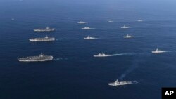 Three U.S. aircraft carriers USS Nimitz, left top, USS Ronald Reagan, left center, and USS Theodore Roosevelt, left bottom, participate, Nov. 12, 2017, with other U.S. and South Korean navy ships during the joint naval exercises between the United States and South Korea in waters off South Korea's eastern coast in South Korea.