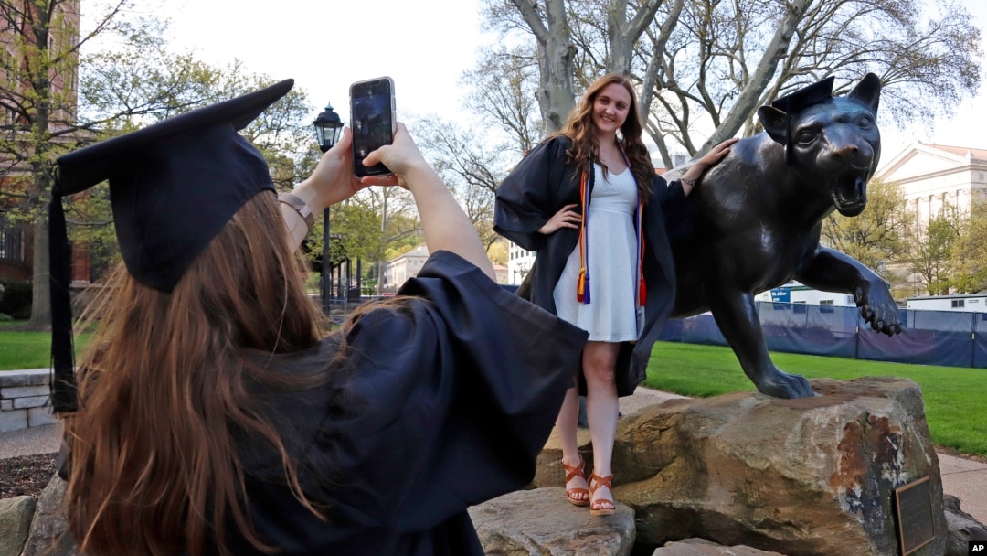 As the coronavirus leaves colleges holding ‘virtual graduation’ events online,class of 2020 University of Pittsburgh graduates Shannon Trombley and Julie Jones take turns posing for photos with a statue of Pitt's mascot, the Pitt Panther.