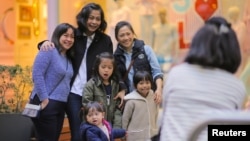 A family poses for a photograph in the World Square shopping center located in central Sydney, Australia, June 26, 2017.