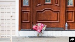 Ramos de flores fueron dejados en la puerta de la casa de un rabino en Monsey, Nueva York, el domingo 29 de diciembre de 2019, tras un ataque con cuchillo en la residencia el sábado por la noche, que dejó cinco heridos. AP/Julius Constantine Motal.