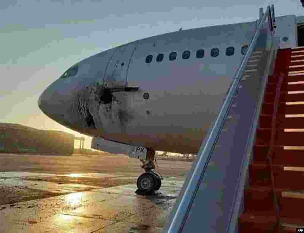 A damaged stationary aircraft is seen on the tarmac of Baghdad airport, after six rockets reportedly targeted the airport, in this handout picture released by the Facebook page of the Iraqi ministry of transportation.