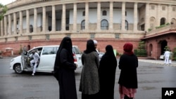 Indian Muslims stand outside Parliament House in New Delhi, India, Friday, July 26, 2019. 