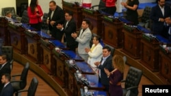 Representatives celebrate after a session of El Salvador's Congress that approved a bill from President Nayib Bukele that overturned a 2017 national ban on metals mining, in San Salvador, Dec. 23, 2024.