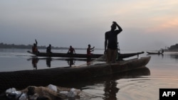 Fishermen are at work on the Ubangui river, which marks the border between the Democratic Republic of Congo and Central Africa in Bangui on Jan. 1, 2016. 