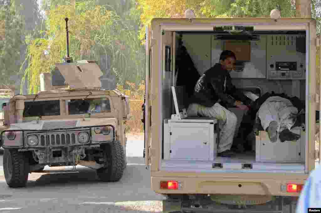 A soldier places the body of a civilian in an ambulance after Taliban insurgents attacked a bank in Helmand province, Dec. 17, 2014.