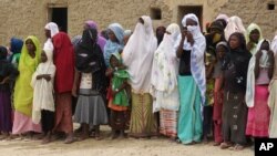 FILE - In this Aug. 31, 2012, photo, women and girls, wearing veils to comply with the dictates of Islamist group Ansar Dine, attend a public lashing in Timbuktu, Mali.