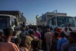 FILE - Refugees who fled the conflict in Ethiopia's Tigray region, wait to receive aid at Umm Rakouba refugee camp in Qadarif, eastern Sudan, Nov. 24, 2020.