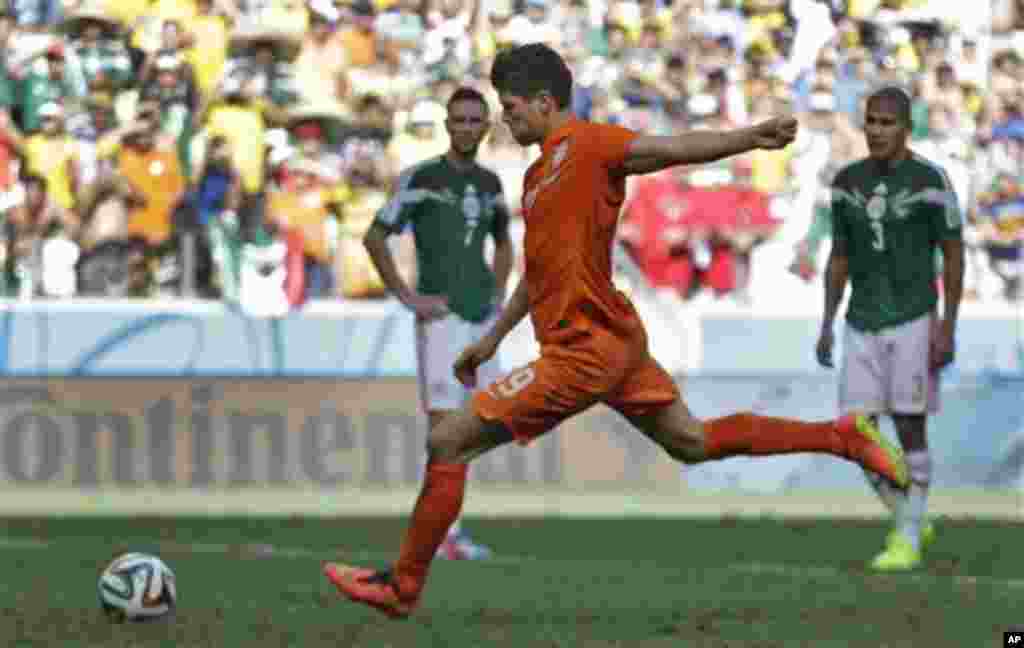 Netherlands' Klaas-Jan Huntelaar scores his side's second goal on a penalty kick during the World Cup round of 16 soccer match between the Netherlands and Mexico at the Arena Castelao in Fortaleza, Brazil, Sunday, June 29, 2014. The Netherlands won the ma