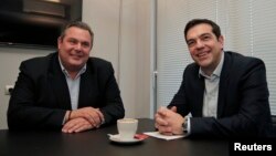 El líder del radical partido Syriza, Alexis Tsipras (derecha) se reune con el líder derechista Panos Kammenos en Atenas, del partido Anel. Ambos llegaron a un acurdo para gobernar.