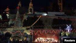 Musicians perform on stage in Manger Square, outside the Church of the Nativity, the site revered as the birthplace of Jesus, on Christmas eve in the West Bank town of Bethlehem, December 24, 2012. 