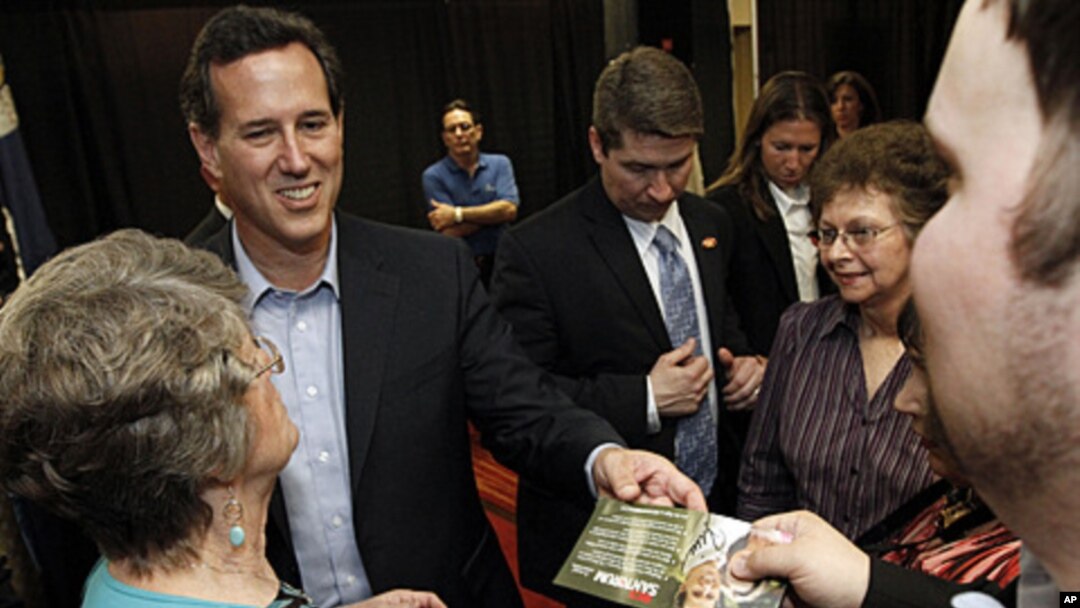 Republican presidential candidate former Pennsylvania Sen. Rick Santorum hands back an autographed campaign flyer at a rally in Shreveport, Louisiana, March 23, 2012. 