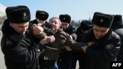 Kazakh police detain a protester in Almaty on March 1, 2020. The country altered some restrictions on public demonstrations on May 25, 2020, but rights groups said they still were too strict.