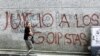 Una transeúnte pasa frente a una inscripción mural dirigida a los militares golpistas, en unas de las principales calles del centro de Caracas, el 15 de agosto de 2002. 