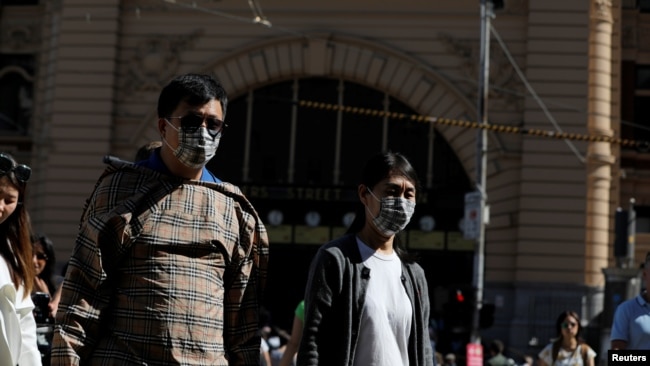 2020年1月29日,在澳大利亚维多利亚州墨尔本确诊了冠状病毒病例后,弗林德斯街车站旁的行人戴着口罩行走。(路透社资料照)