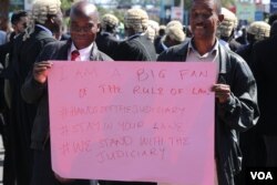 Protesters carry a sign during a demonstration against what they call government interference in the judiciary, in Blantyre, Malawi, June 17, 2020. (Lameck Masina/VOA)