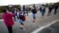 FILE - A teacher screens students for the coronavirus in Langa township in Cape Town, South Africa, June 8, 2020.