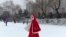 A girl wears a face mask as she walks across a frozen canal during a snowfall in Beijing, Feb. 5, 2020. The little-understood new coronavirus has killed nearly 500 people in mainland China, but it has also spread panic and discrimination around the world.