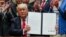 FILE - President Donald Trump holds up a signed executive order in the Roosevelt Room of the White House in Washington directing the Interior Department to begin a review of restrictive drilling policies for the outer continental shelf, April 28, 2017. 