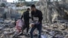 加沙南部拉法的巴勒斯坦人在被以色列炸毁的废墟里寻找个人物品。（2024年3月11日）