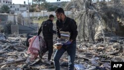 加沙南部拉法的巴勒斯坦人在被以色列炸毁的废墟里寻找个人物品。（2024年3月11日）