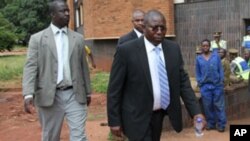 FILE: Elton Mangoma, centre, former Zimbabwe's Minster of Energy and Power Development outside the magistrates courts, accompanied by two unidentified police detectives in Harare, Friday, March, 11, 2011.