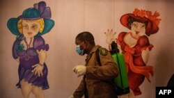 Un gardien de prison désinfecte la section réservée aux femmes du centre correctionnel de Johannesburg, également connue sous le nom de Sun City Prison, le 8 avril 2020. (Photo de Michele Spatari / AFP)