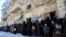 FILE - Women and children queue to receive free meals in Aleppo, Syria, Feb. 2, 2017. 