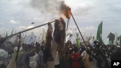 Muslims burn a US flag and a portrait of U.S. President Barrack Obama following a protest in Kano, Nigeria, September 22, 2012.