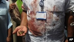 A Pakistani security official displays cartridges from the scene of an attack on a bus that was bound for a Shiite community center in southern Pakistan when gunmen attacked it, Karachi, May 13, 2015. 