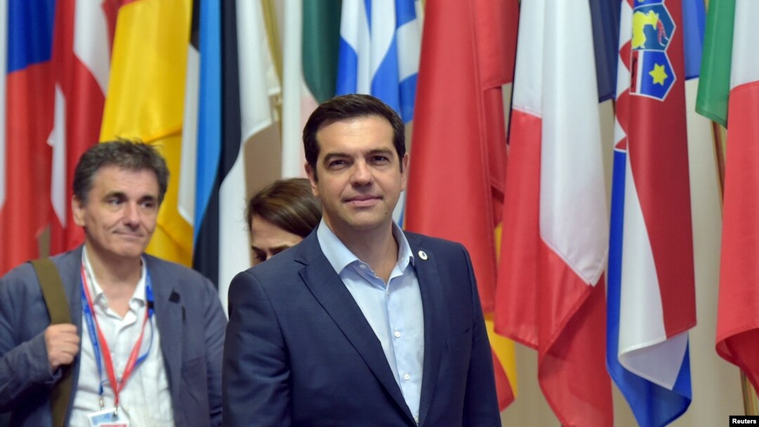 Perdana Menteri Yunani Alexis Tsipras (tengah) dan Menteri Keuangan Yunani Euclid Tsakalotos meninggalkan KTT pemimpin zona euro di Brussels, Belgia (13/7). 