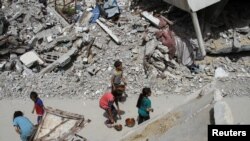 Sejumlah anak-anak berjalan membawa bantuan makanan di wilayah Jabalia, di utara Jalur Gaza, pada 22 April 2024. (Foto: Reuters/Mahmoud Issa)