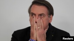 Brazil's President Jair Bolsonaro gestures during a signing ceremony for 13.2 billion reais in contracts for electricity transmission lines, at the Planalto Palace in Brasilia, Brazil, March 25, 2019. 