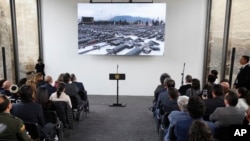 Invitados esperan el inicio de la ceremonia de inauguración de un piso hecho con armas derretidas en Bogotá, Colombia, el martes 31 de julio de 2018.