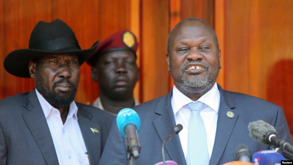 FILE: South Sudan's First Vice President and Chairman of the SPLM-In-Opposition party, Riek Machar, flanked by President Salva Kiir Mayardit, addresses a news conference at the State House in Juba, South Sudan February 20, 2020. REUTERS/Jok Solomun.