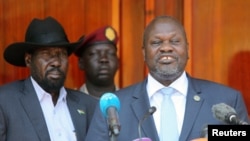 FILE: South Sudan's First Vice President and Chairman of the SPLM-In-Opposition party, Riek Machar, flanked by President Salva Kiir Mayardit, addresses a news conference at the State House in Juba, South Sudan February 20, 2020. REUTERS/Jok Solomun.