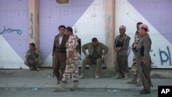 An image from a Sept. 8, 2014 video shows Kurdish Peshmerga standing on a street in Gwer, a northern Iraq town that was recently freed from Islamic State control.