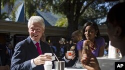 Former U.S. President and U.N. special envoy to Haiti, Bill Clinton, left, holds a coffee before the opening ceremony of an investor conference at the Karibe hotel in Port-au-Prince, Haiti, November 29, 2011.