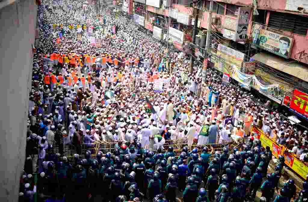 Supporters of Islami Andolan Bangladesh, an Islamist political party, face policemen during a protest against French President Emmanuel Macron and against the publishing of caricatures of the Prophet Muhammad they deem blasphemous, in Dhaka, Bangladesh.