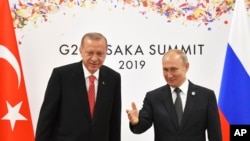 FILE - Russian President Vladimir Putin, right, and Turkish President Recep Tayyip Erdogan attend their bilateral meeting on the sidelines of the G-20 summit in Osaka, June 29, 2019. 